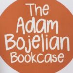 Big orange sign saying The Adam Bojelian Bookcase in white letters